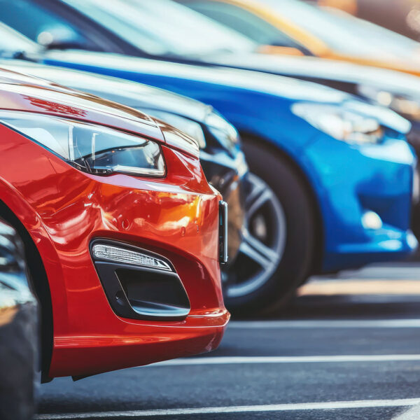 Cars parked in rows in an outdoor dealership or storage yard.