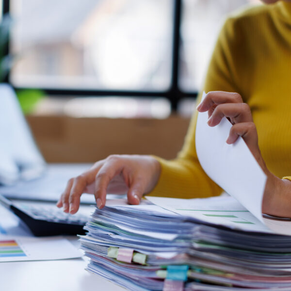 Person reviewing reports and paperwork with charts and graphs during business continuity planning.