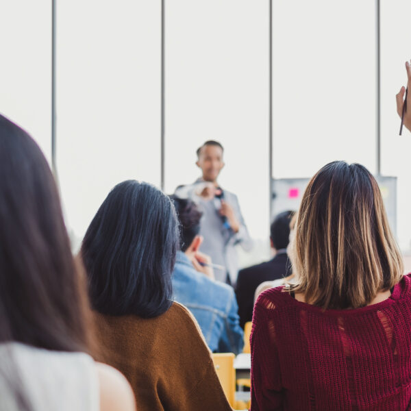 A group of people seated around a table in discussion during a workplace training session, illustrating a typical health and safety meeting environment.