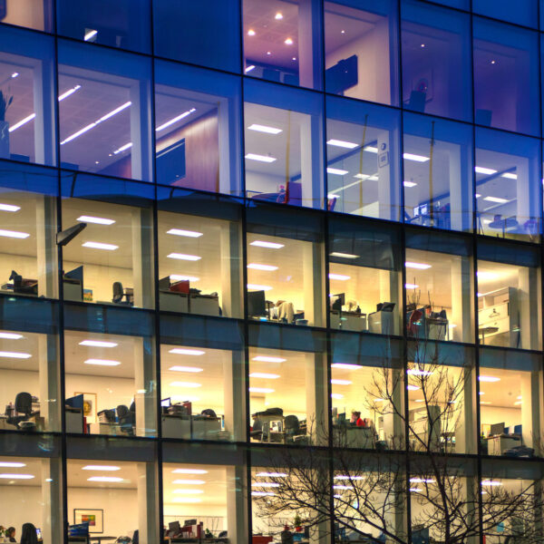 Modern office building with illuminated windows at night.