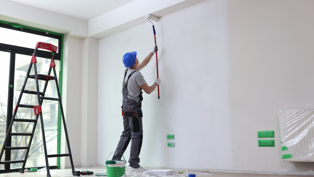 Painter decorating an interior wall with a roller