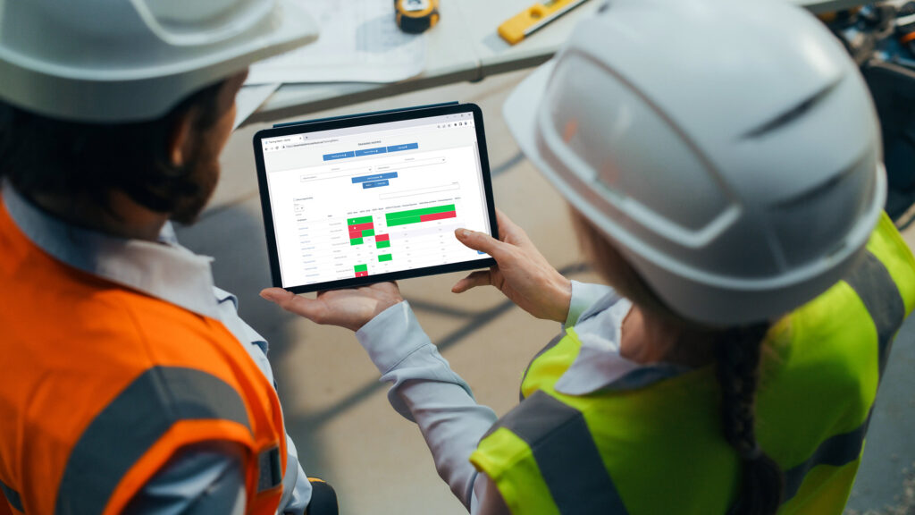 Two workers viewing the xCenta Training Matrix on a tablet